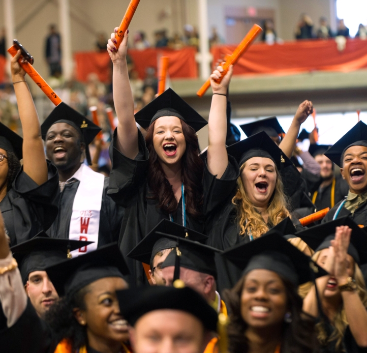 Joyful grads waving their diplomas